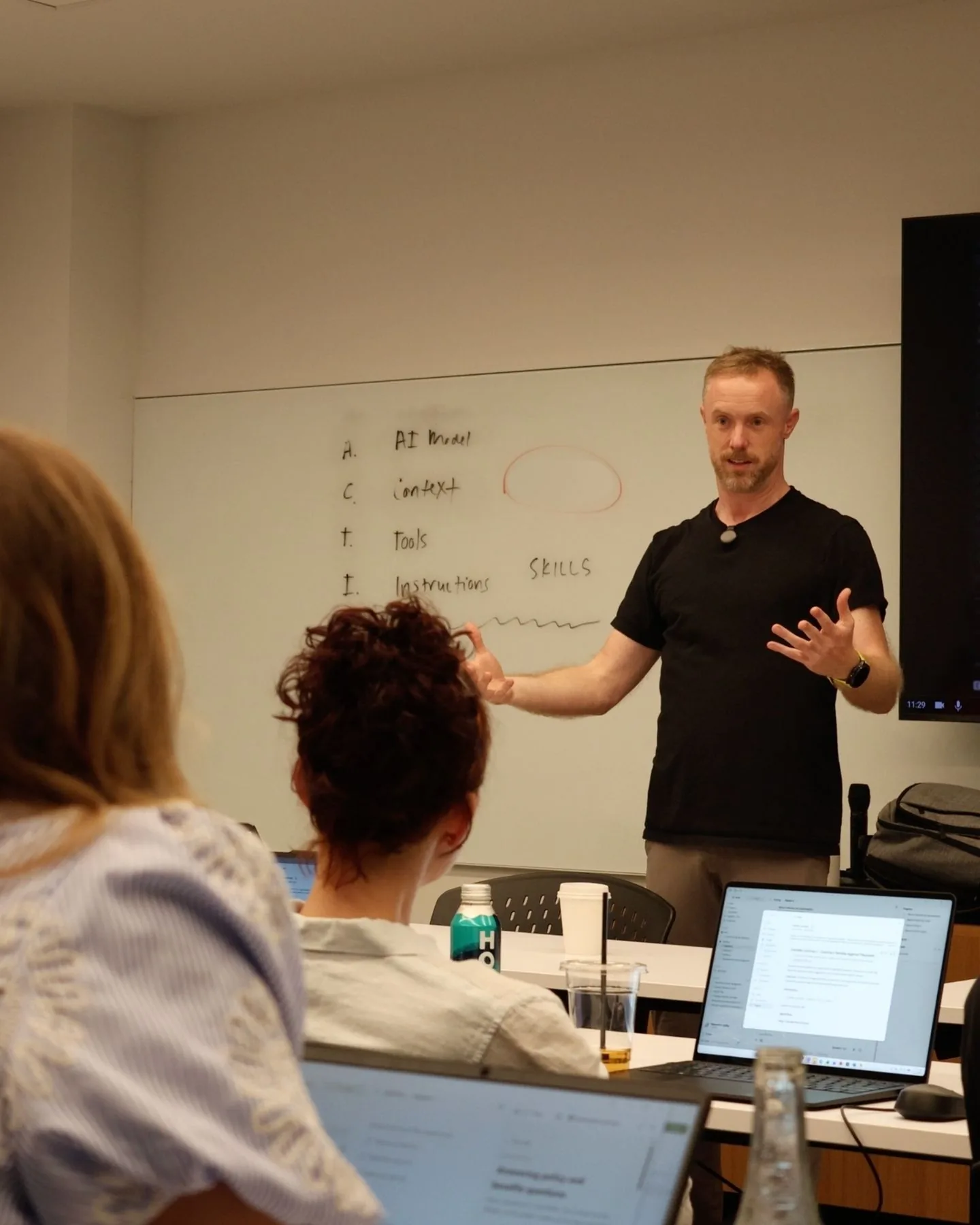 A Caravan instructor explaining a concept to participants at their laptops