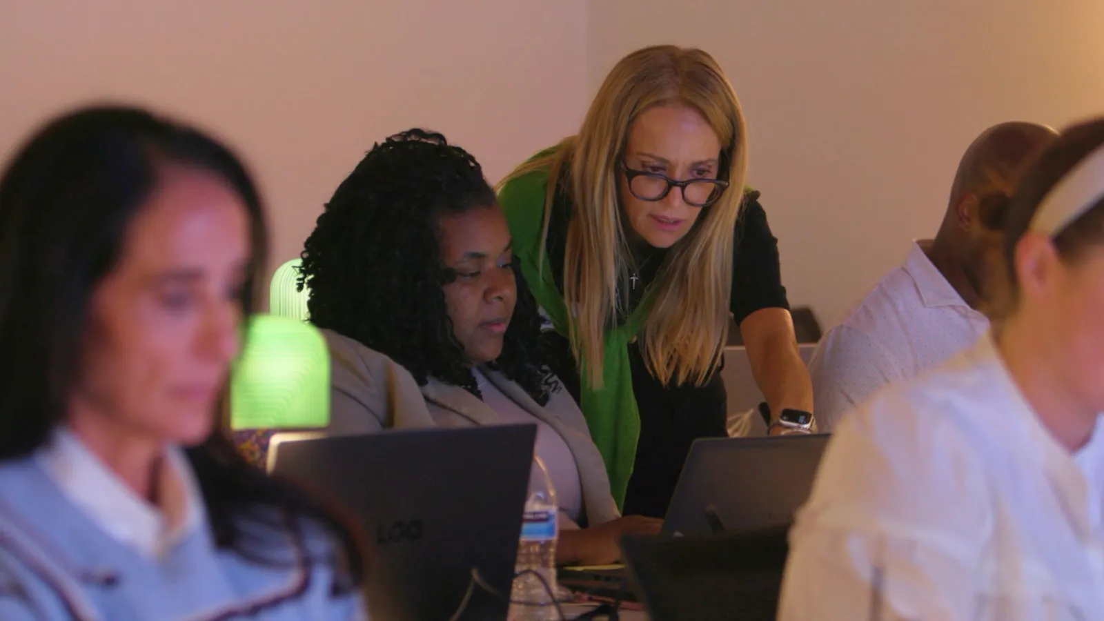 A Caravan instructor helping participants at their laptops