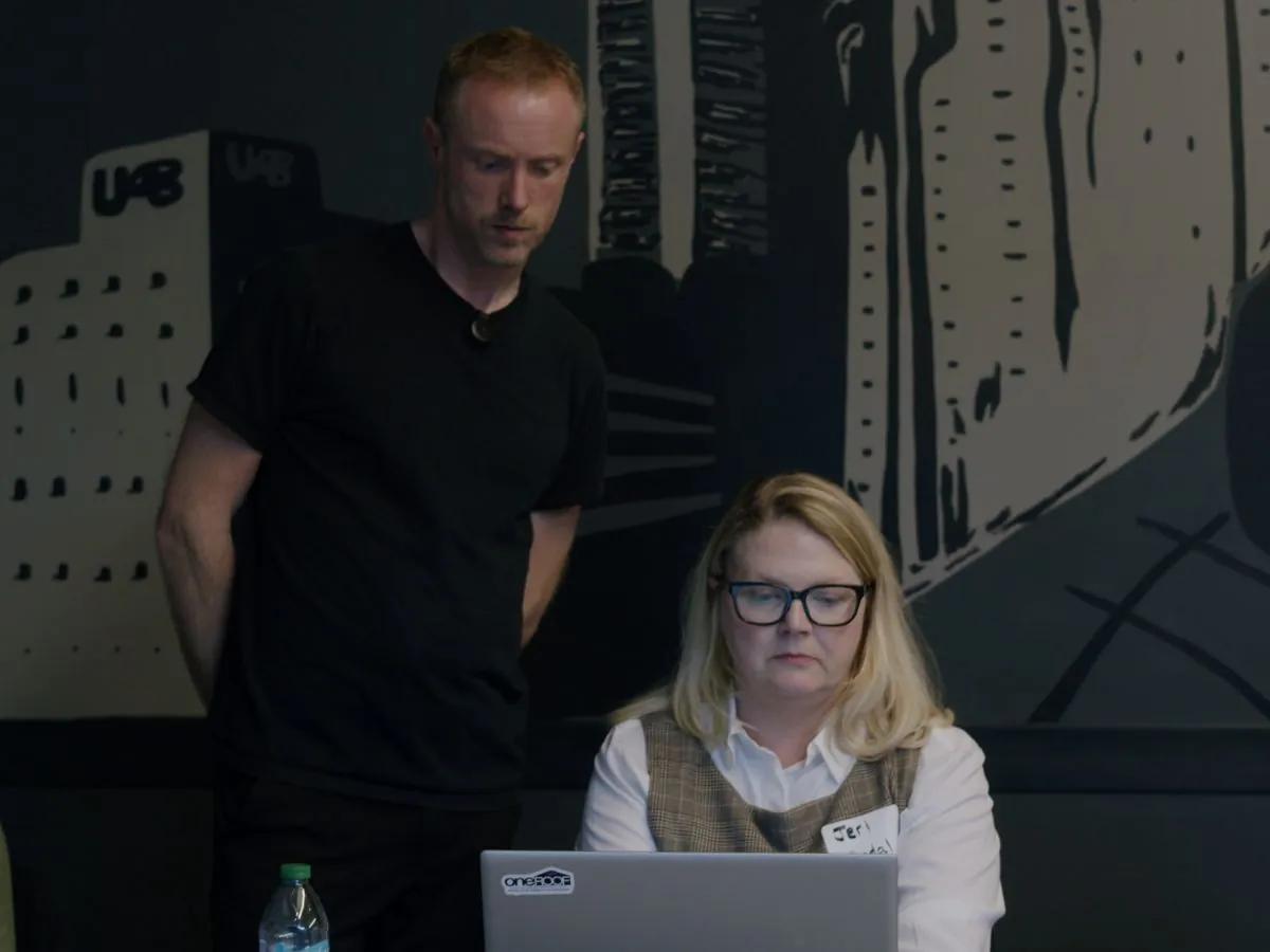 A Caravan instructor helping a participant at a laptop